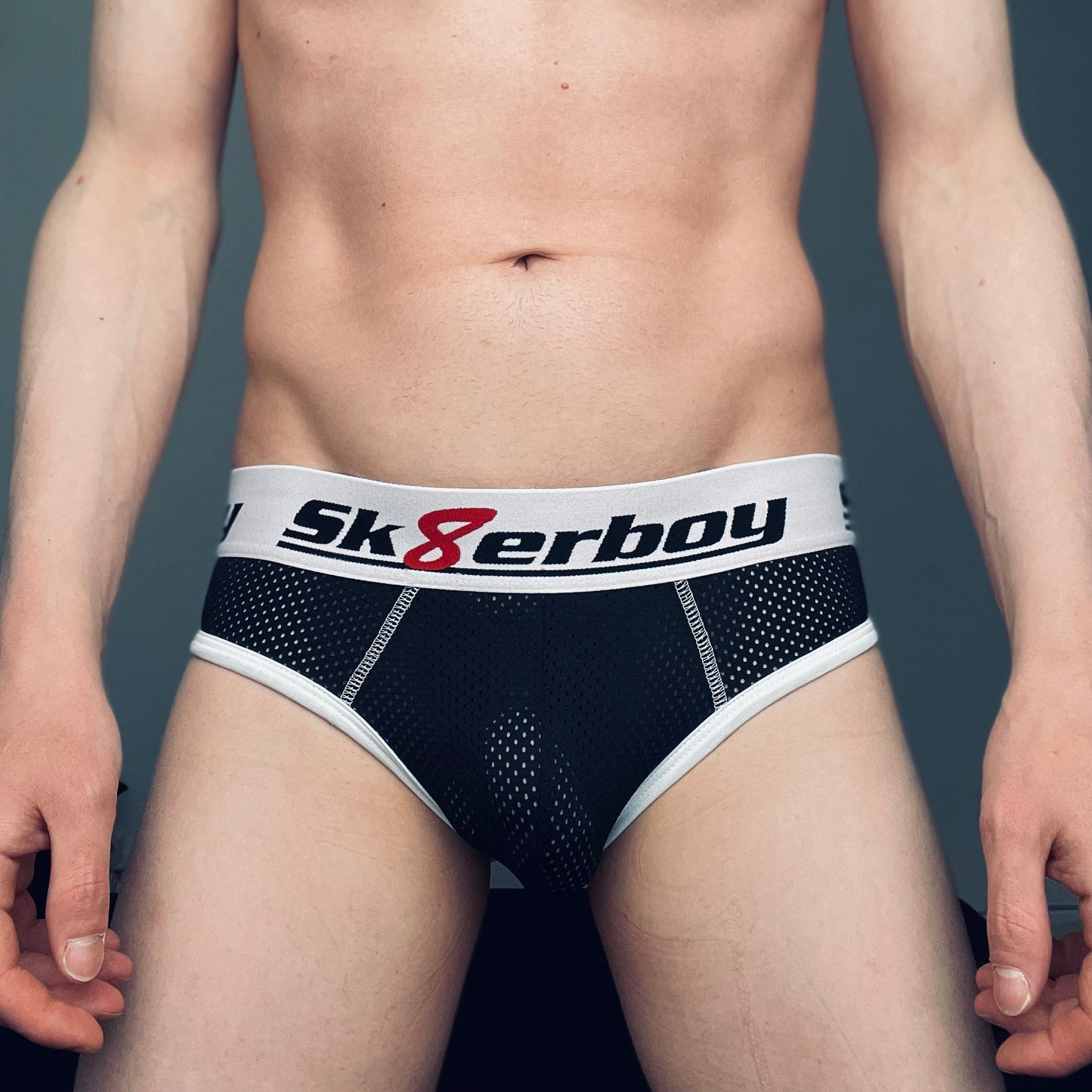 junger gay zeigt seinen koerper und traegt eine schwarze mesh unterhose mit freiem hinterteil von sk8erboy mit großem logo am breiten bund