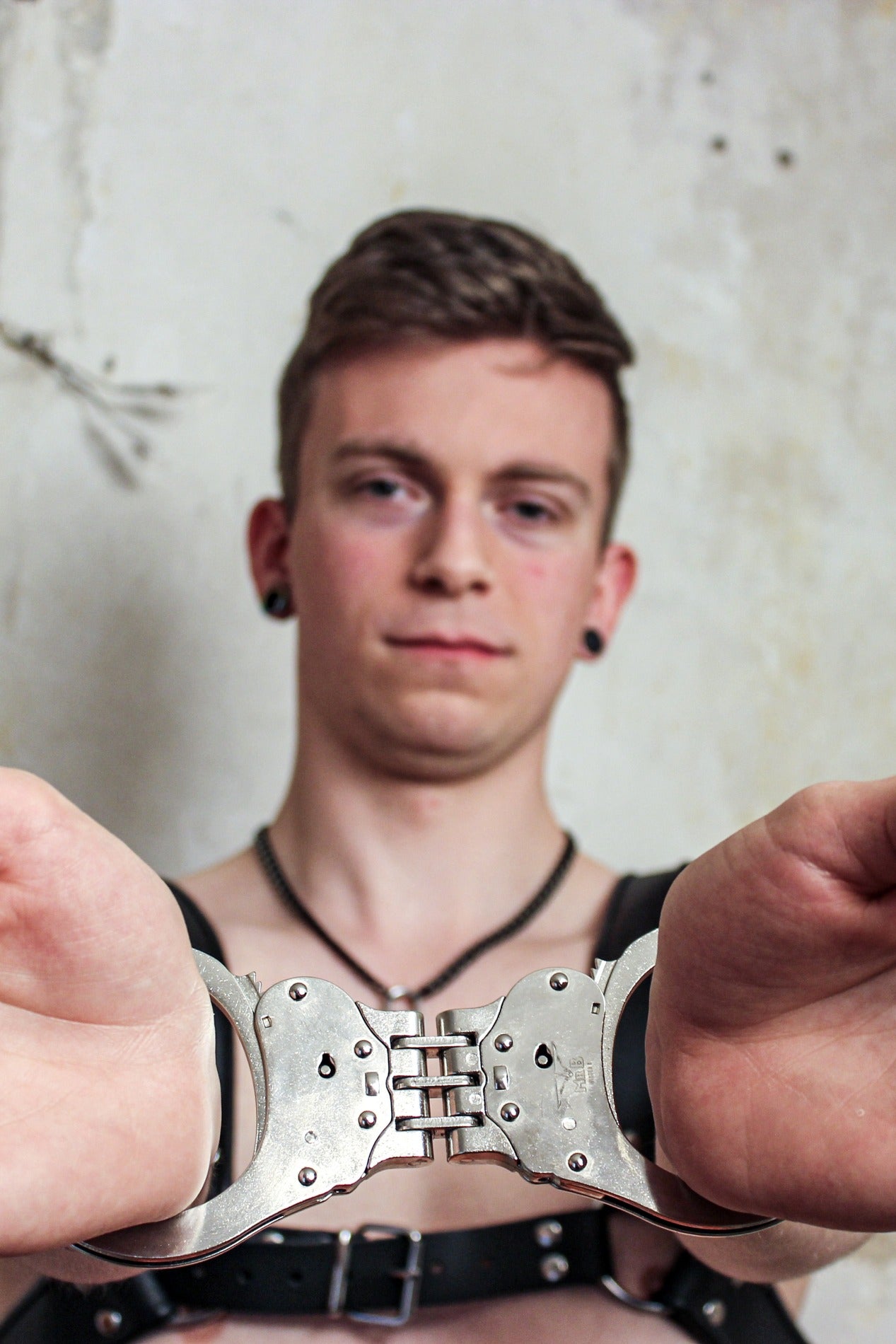 junger gay mit Mister B Handschellen aus vernikeltem Stahl und zwei schlüssel bei sk8erboy im shop für bdsm und gay bondage