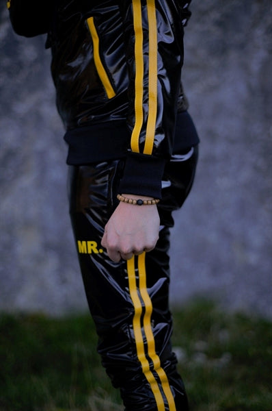 MR Riegillio PVC Tracksuit jacke mit gelben streifen von einem jungen gay getragen in schwarz glänzend von der seite