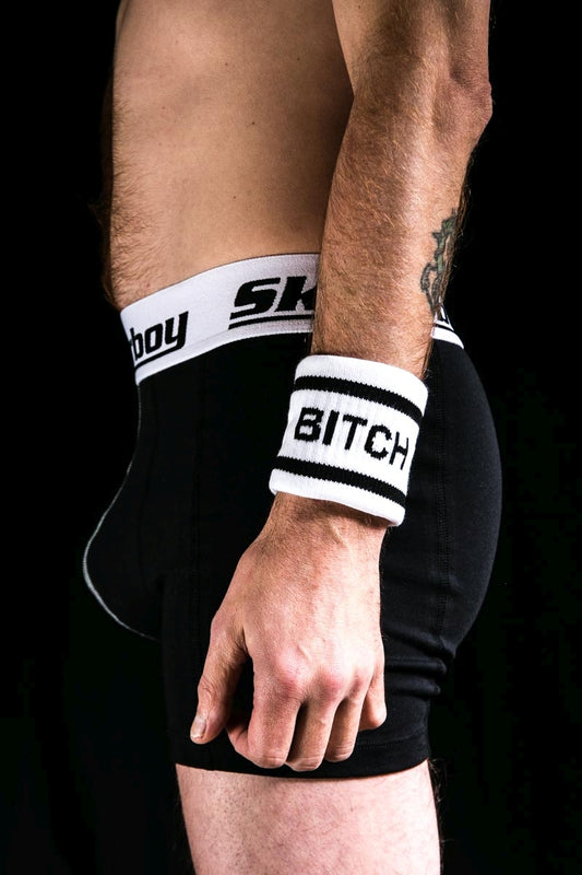 gay im dunkeln mit schwarzer sk8erboy boxershort und schweissband am linken arm mit der aufschrift bitch von sk8erboy socken shop