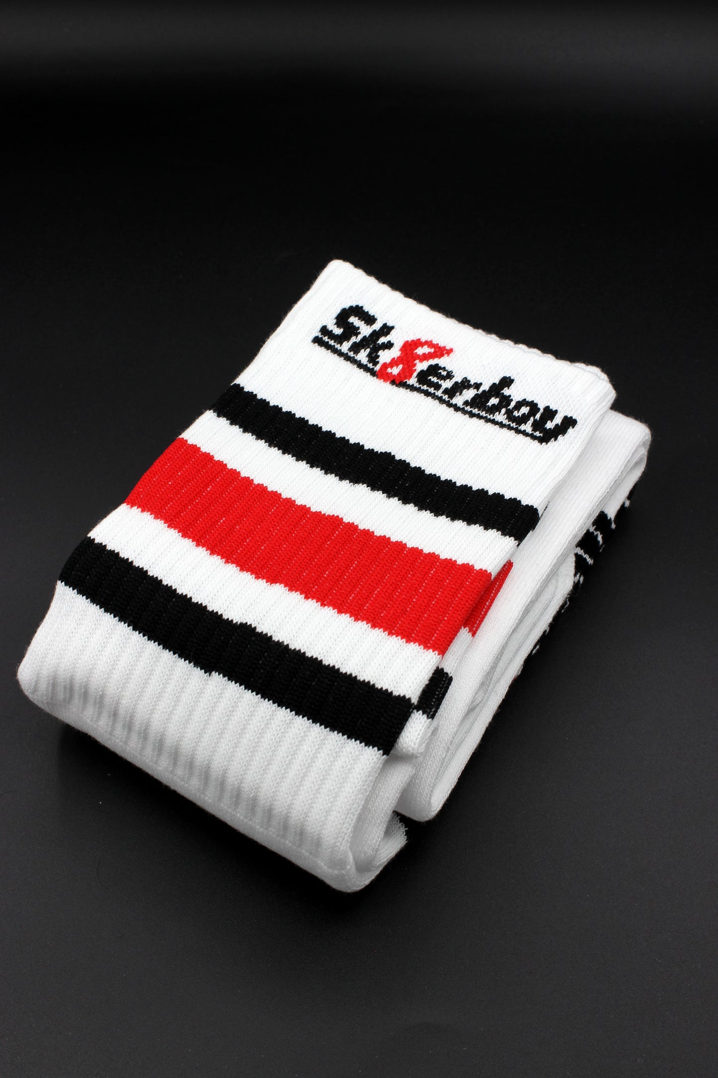 detailansicht der sk8erboy tube socks in einheitsgrösse und schwarz weiss rotem balken am bund mit großem logo