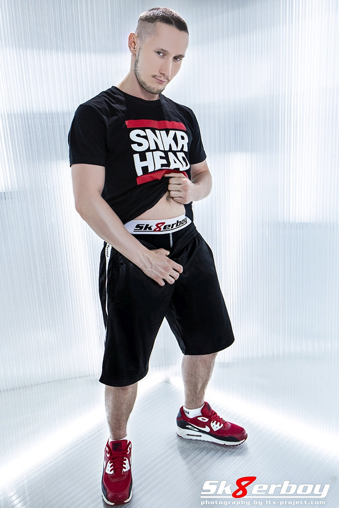 sportlicher junge mit glanz short von sk8erboy und roten nike sneaker traegt ein schwarzes snkr head t-shirt von sk8erboy und passender boxershort