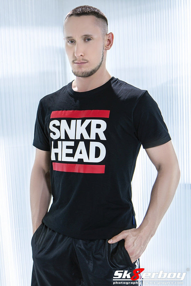 junger gay mit glanzhose von sk8erboy und snkr head t-shirt in schwarz mit weisser schrift und roten balken