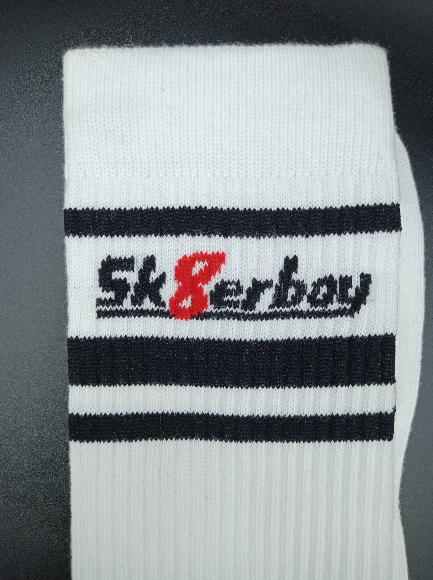 sk8erboy victory socken extra dünn in bekannter qualität jedoch besonders leicht und ideal für den sommer in weiss und nahaufnahme vom bund mit großem sk8erboy-logo